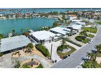 Stunning waterfront home featuring lush landscaping and a private dock on a canal leading to the open bay at 25 Dolphin Dr, Treasure Island, FL 33706