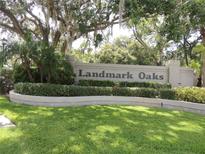 Landmark Oaks community sign surrounded by lush greenery and mature trees at 3016 Landmark Blvd # 401, Palm Harbor, FL 34684