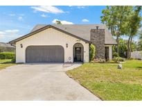 Charming single-story home with a stone chimney and attached two-car garage at 3626 Lake Joyce Dr, Land O Lakes, FL 34639