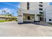 Modern condominium building entrance with palm trees and well-maintained landscaping at 5940 Pelican Bay S Plz # 504, Gulfport, FL 33707