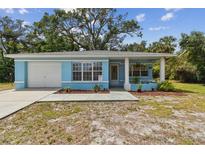 Charming, light-blue single story home with attached garage and a cozy, welcoming front yard at 711 6Th Ne St, Largo, FL 33770