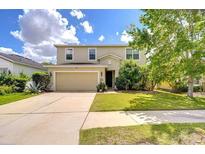 Two-story home featuring a well-manicured lawn, a two car garage, and neutral colored siding at 11231 Spring Point Cir, Riverview, FL 33579