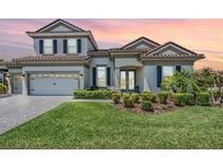 Charming two-story home with a well-manicured lawn, a two-car garage, and a tile roof at 13121 Pasture View Loop, Riverview, FL 33579