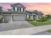 Charming two-story home with a brick driveway, well-manicured lawn, and a tile roof at 13121 Pasture View Loop, Riverview, FL 33579