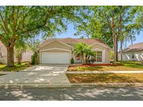 Charming single-story home featuring a well-maintained lawn and mature trees for ample shade and privacy at 1610 Navigator Ln, Tarpon Springs, FL 34689