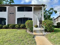 Inviting condo exterior featuring well-maintained landscaping and a private entrance at 3025 Bonaventure Cir # 103, Palm Harbor, FL 34684
