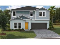 Charming two-story home with gray siding, a yellow front door, and an attached two-car garage at 37087 Sagemoor Dr, Zephyrhills, FL 33541
