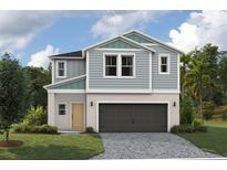 Charming two-story home with a two-car garage, light blue wood paneling and a well-manicured lawn at 37230 Sagemoor Dr, Zephyrhills, FL 33541