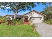 Charming single-story home with lush landscaping and a vibrant red front door, creating an inviting curb appeal at 7201 15Th Ne Ct, St Petersburg, FL 33702