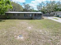 Charming single-story home with a screened-in porch and well-maintained front yard at 827 Louise St, Brandon, FL 33511
