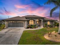 Charming single Gathering home featuring well manicured landscaping and a screened two car garage at 121 Colonial Sw St, Port Charlotte, FL 33952