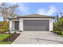 Charming single-story home with a gray garage door and a beautifully paved driveway at 1721 Shevlin St, North Port, FL 34286