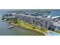 Beautiful condo building with mature landscaping, a pier, and a swimming pool overlooking the ocean at 1847 Shore S Dr # 507, South Pasadena, FL 33707