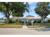 Charming single-story home featuring a well-maintained lawn, mature trees, and a welcoming walkway at 3918 Versailles Dr, Tampa, FL 33634