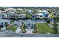Well-maintained waterfront home with a two-car garage, palm trees, and a circle driveway at 4290 Carlos Ct, Hernando Beach, FL 34607