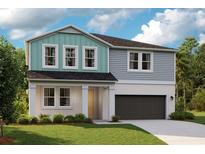 Charming two-story home featuring a two-car garage, landscaped yard, and craftsman-style architectural details at 12164 Cattleside Dr, Riverview, FL 33579