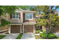 Two-story townhome featuring attached garages and well-manicured landscaping at 2009 River Turia Cir, Riverview, FL 33578