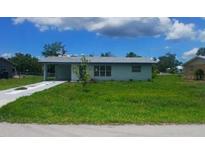 Charming single-story home featuring a well-maintained lawn and a quaint, inviting facade at 2801 Poinciana Ct, Punta Gorda, FL 33950