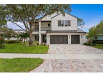 Stunning two-story modern farmhouse-style home with a manicured lawn and three-car garage at 3406 W Alline Ave, Tampa, FL 33611