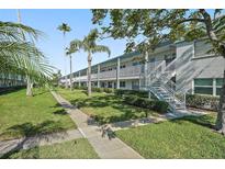 Well-maintained condo building with lush landscaping, sidewalk and staircase at 5246 81 N St # 24, St Petersburg, FL 33709
