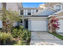 Light blue two-story townhouse with a white garage door and lots of Florida landscaping at 6236 Olivedale Dr, Riverview, FL 33578