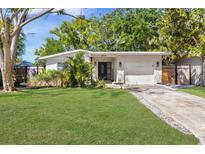 Charming single-story home with lush green lawn, modern front door, and attached garage in a desirable neighborhood at 10074 Bahama Ct, Seminole, FL 33776