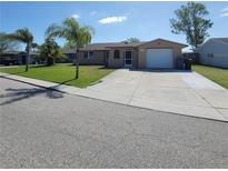 Charming single-story home with a well-maintained lawn and a two-car garage at 2110 Society Dr, Holiday, FL 34691