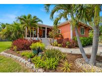 Charming home boasts tropical landscaping and a welcoming front porch with white pillars at 2623 57Th S St, Gulfport, FL 33707