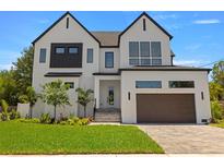 Stunning two-story home boasts modern design, white brick, black accents, and a manicured front yard at 3020 W Helen Ave, Tampa, FL 33611