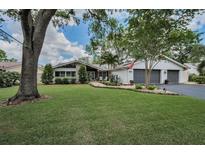 Charming single-story home with a well-manicured lawn, lush landscaping, and a welcoming walkway to the front door at 3603 Schefflera Rd, Tampa, FL 33618