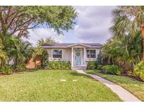 Charming home featuring a lush green lawn, inviting walkway, and beautiful, mature landscaping at 477 44Th N Ave, St Petersburg, FL 33703