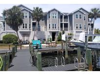 Dockside view of complex and boat with boat lift; great for waterfront living at 5712 Biscayne Ct # 203, New Port Richey, FL 34652