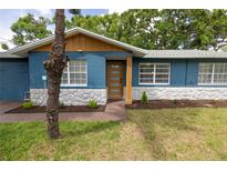 Charming single-story home with blue paint, white stone accents, and a modern front door at 5806 12Th S Ave, Tampa, FL 33619
