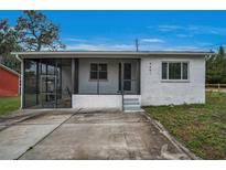 Charming single-story home with a screened front porch and inviting curb appeal in a lush setting at 9451 Lake Dr, New Port Richey, FL 34654