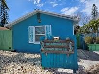 Charming beach house features a vibrant blue exterior and unique address signage at 126 119Th Ave, Treasure Island, FL 33706