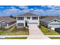Charming two-story home with blue shutters, manicured lawn, and a spacious driveway at 18023 Canopy Pl, Bradenton, FL 34211