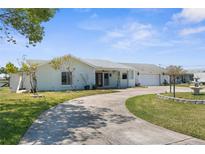 Charming single-story home features a circular driveway, attached garage, and well-manicured lawn at 4210 Headsail Dr, New Port Richey, FL 34652