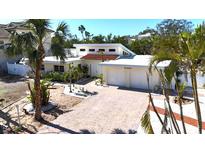 Charming single-story home featuring a brick driveway, two-car garage, and lush landscaping with palm trees at 5430 Avenida Del Mare, Sarasota, FL 34242