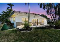 Charming single-story home with lush green lawn and mature palm trees offering curb appeal at 5619 New York Ave, Sarasota, FL 34231