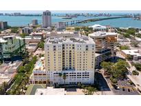 An aerial view showcases the condominium, along with waterfront scenery, bridges, and downtown buildings at 628 Cleveland St # 612, Clearwater, FL 33755