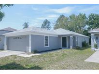 Charming single-story home with a well-maintained lawn and attached two-car garage at 10728 Navigation Dr, Riverview, FL 33579
