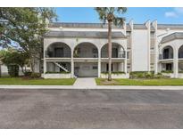 Charming condo building with an elegant arched entryway and lush landscaping at 122 N Kings Ave # 101, Brandon, FL 33510