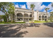 Inviting condo building with archways, second-floor balconies, lush landscaping, and well-maintained sidewalks at 122 N Kings Ave # 101, Brandon, FL 33510