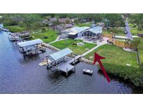 Waterfront home boasts a covered dock with boat lift and sprawling lawn for outdoor activities at 202 7Th Sw St, Ruskin, FL 33570