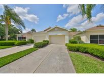 Inviting single-story home with a manicured lawn, mature trees, and a private two-car garage at 2220 Nantucket Dr # 43, Sun City Center, FL 33573