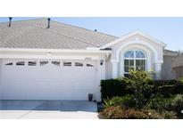 Charming home featuring a two-car garage, well-maintained landscaping, and an inviting arched window at 2802 Torrance Dr, Land O Lakes, FL 34638