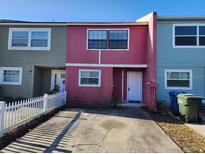 Charming townhouse featuring a colorful exterior, front yard, and private driveway, perfect for comfortable living at 3040 S Pines Dr # 95, Largo, FL 33771