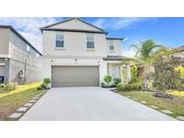 Charming two-story home featuring a well-maintained yard and an attached two-car garage at 582 Royal Empress Dr, Ruskin, FL 33570