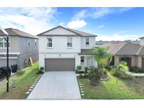 Charming two-story home features a well-manicured lawn and an attached two-car garage at 582 Royal Empress Dr, Ruskin, FL 33570