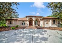Stunning home featuring a manicured lawn, fountain, and unique architecture with arches at 7333 Royal Oak Dr, Spring Hill, FL 34607